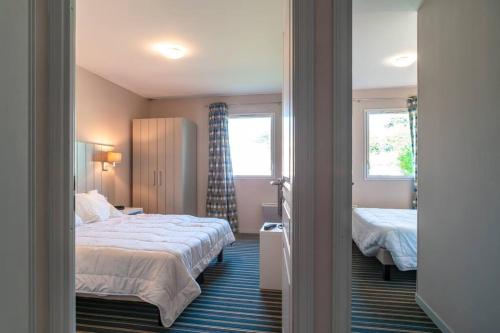 une chambre d'hôtel avec un lit et une fenêtre dans l'établissement Les Thermes 408 - Appt pour 4 avec piscine partagée, à Concarneau