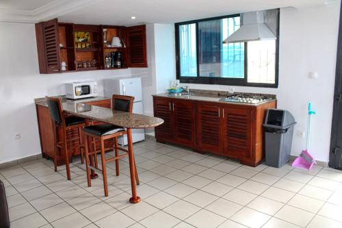 a kitchen with a counter and a table and chairs at Residence Blue Sky in Douala