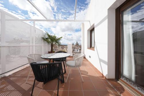 un balcón con mesa y sillas. en numa I Vega Apartments, en Granada