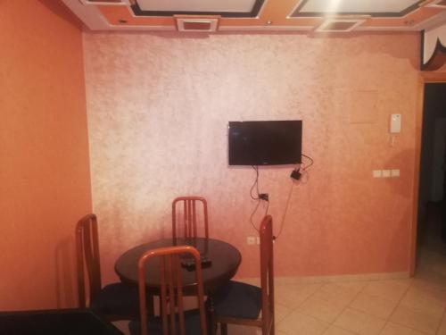 Camera con tavolo e TV a parete di Appartement Boekidan/Al houceima 