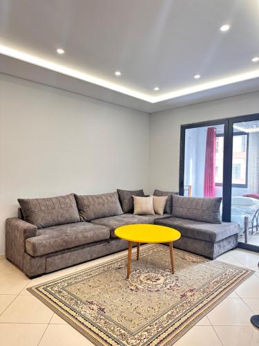 ein Wohnzimmer mit einem Sofa und einem gelben Couchtisch in der Unterkunft Tirana Apartment in Kashari