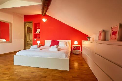 a bedroom with a red wall and a white bed at Moscova Charme Apartment in Milan