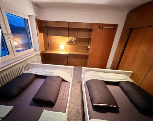 two beds in a small room with a window at Beautiful Apartment in Ibbenbüren in Ibbenbüren