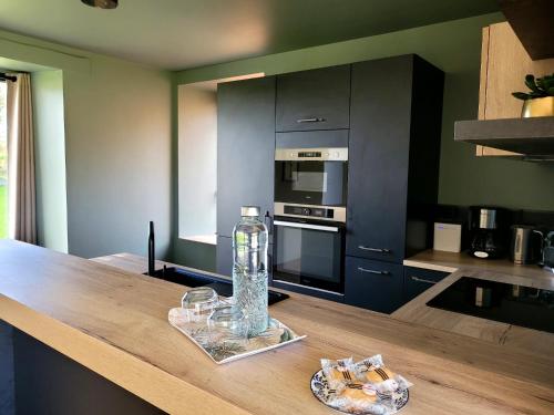 - une cuisine avec une bouteille d'eau sur un comptoir en bois dans l'établissement le jardin médicis gîte avec Spa Jacuzzi et sauna, à Trédion