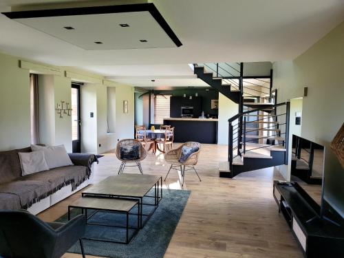 a living room with a couch and a table at Le jardin Médicis avec jacuzzi et sauna in Trédion