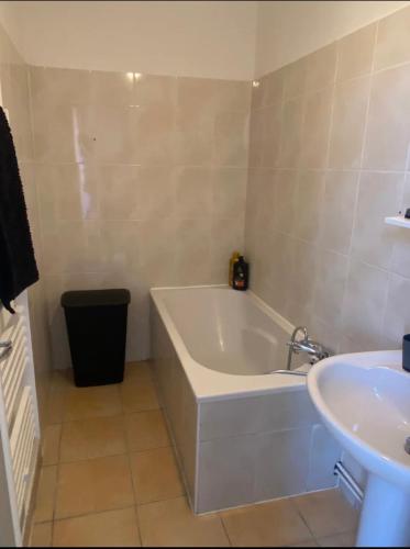 une salle de bain avec une baignoire et un lavabo dans l'établissement Liberté 2 -Spacieux Appartement proche Polygone et centre ville - Beziers - Wifi - Tv Connecté, à Béziers