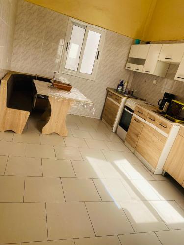 a kitchen with a table in the middle of it at Idéal et meilleur Appart du coin Guediawaye in Pikini Bougou