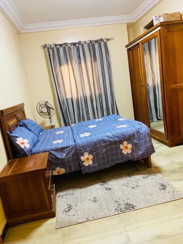 a bedroom with a bed with a blue comforter at Idéal et meilleur Appart du coin Guediawaye in Pikini Bougou