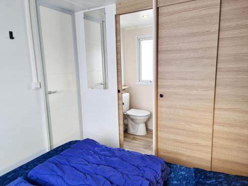 a bedroom with a bed and a toilet in it at Prachtig chalet OK50 D12 op familiecamping in Oostkapelle