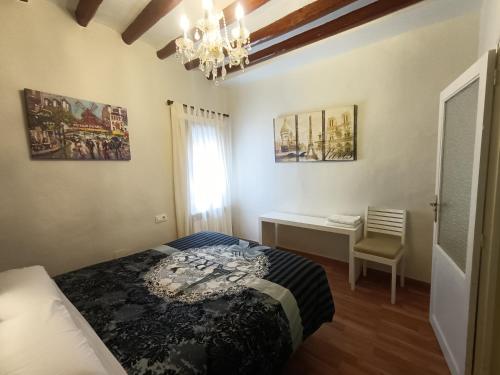 a bedroom with a bed and a desk and a chandelier at Rey Mundo in Munébrega