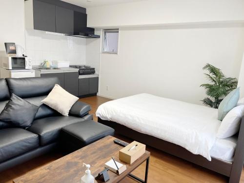 a living room with a bed and a couch at Coral Gate in Kume コーラルゲートイン久米 in Naha