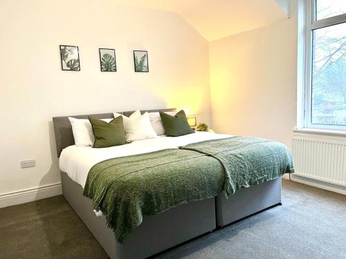 a bedroom with a bed with a green blanket at 2Bed House-10min drive to Durham in New Brancepeth