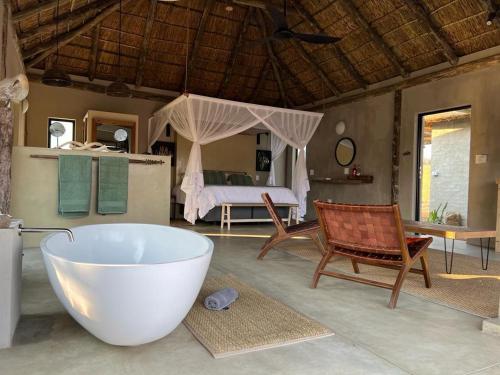 a bathroom with a tub and a bedroom with a bed at LookOut Safari Lodge in Klipdrift