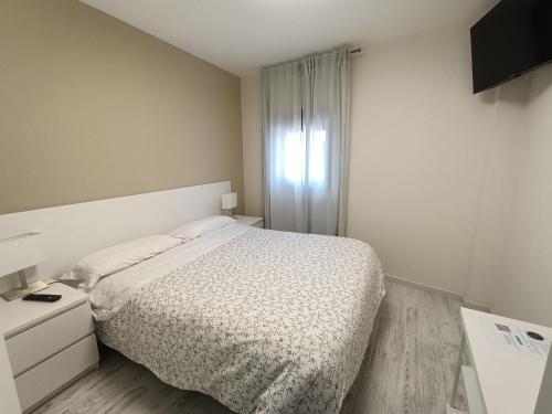 a white bedroom with a bed and a window at Rey Mundo in Munébrega