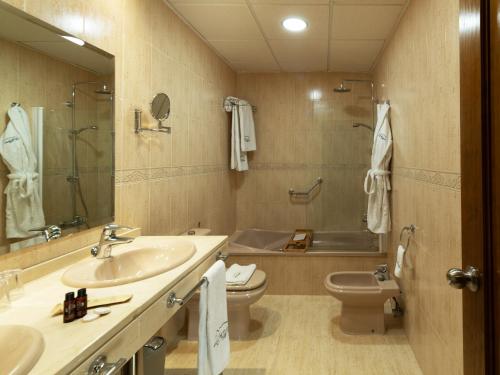 a bathroom with a sink and a toilet and a tub at Hotel Altos de Istán in Istán