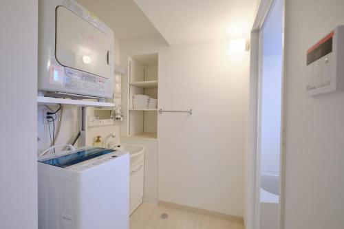 a white laundry room with a washer and dryer at Coral Gate in Kume コーラルゲートイン久米 in Naha