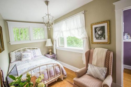 a bedroom with a bed and a chair and a window at Charles Street Vacation Home in Lethbridge