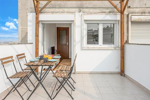 a patio with a table and chairs on a balcony at Sunny Apt in Almada with Tejo View in Almada