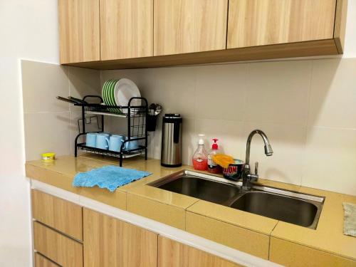 a kitchen with a sink and a counter top at Homestay Manitha in Seri Manjung