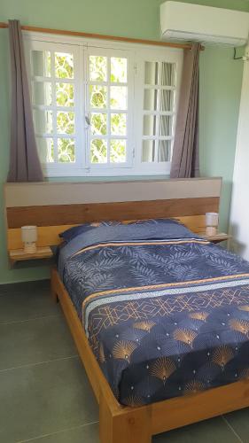 una cama en una habitación con ventana en Villa Zeinga, en Sainte-Anne