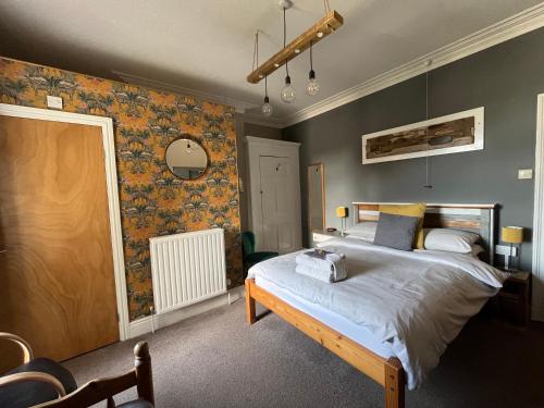 a bedroom with a large bed and a wall at Kelston Guest House in Weymouth