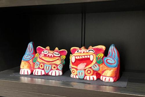 a group of three figurines sitting on a shelf at Coral Gate in Kume コーラルゲートイン久米 in Naha
