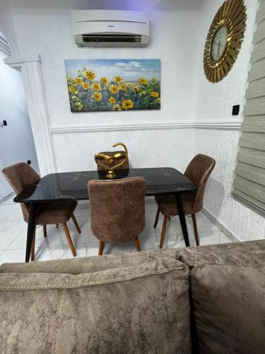 a dining room with a black table and chairs at Kemc apartment in Ashalebotwe