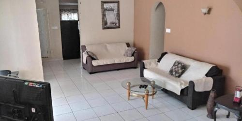 a living room with two couches and a tv at Portmore Havens 1Bedroom EntireGuest House in Portmore