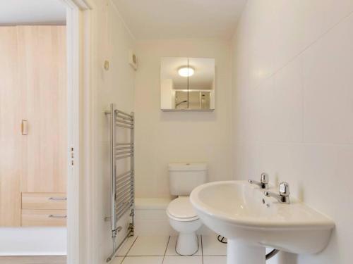 La salle de bains blanche est pourvue de toilettes et d'un lavabo. dans l'établissement Pass the Keys Cosy Cabin in Central Cambridge Free Parking, à Cambridge