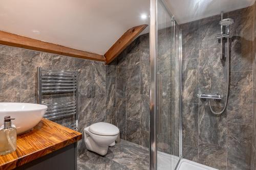 a bathroom with a shower and a toilet and a sink at No93 Boutique Guest House in Easingwold