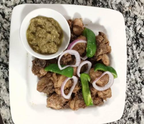 a plate of food with a bowl of dipping sauce at Joyous AP Guest House in Aburi