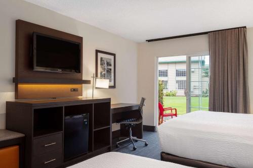 a hotel room with a bed and a desk with a computer at Ramada by Wyndham Spokane Airport in Spokane