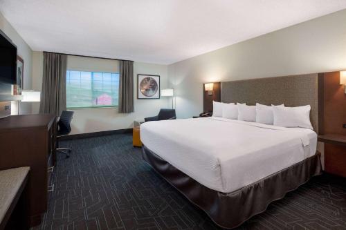a hotel room with a large bed and a window at Ramada by Wyndham Spokane Airport in Spokane