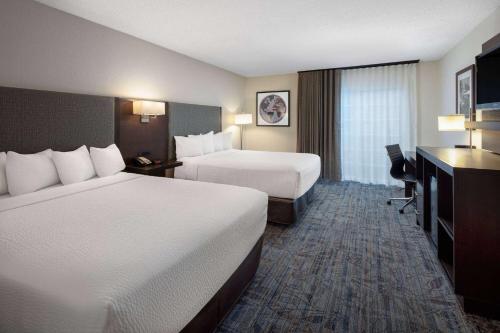 a hotel room with two beds and a television at Ramada by Wyndham Spokane Airport in Spokane