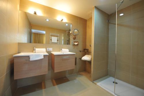 a bathroom with two sinks and a shower at Das Reinisch Hotel & Restaurant in Schwechat