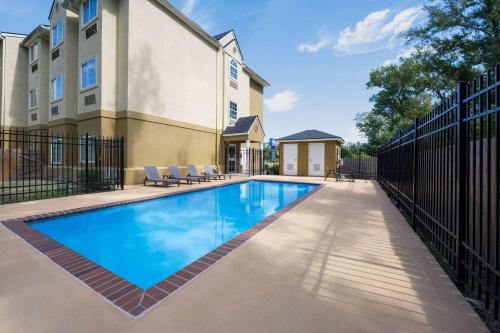 a swimming pool in front of a building at Microtel Inn & Suites by Wyndham of Houma in Houma