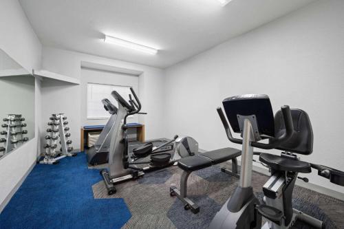 a gym with several tread machines in a room at Microtel Inn & Suites by Wyndham of Houma in Houma
