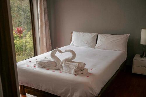 a bed with a swan made out of confetti at OKA Forest Lodge in Andasibe