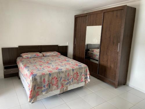una camera con un letto e un grande armadio in legno di Guilherme Hostel a Fortaleza
