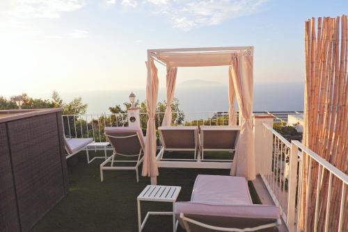 阿納卡普里的住宿－B&B La Danza del Mare，一个带椅子的阳台和一个凉亭
