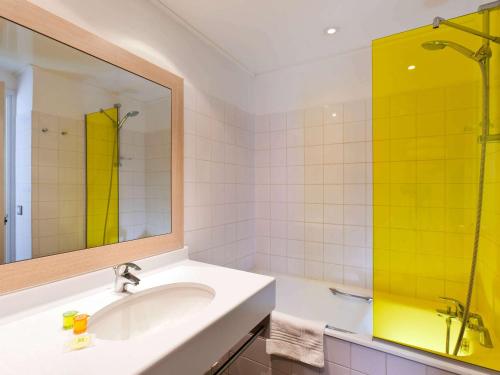 y baño con lavabo, espejo y ducha. en ibis Styles Honfleur Centre Historique, en Honfleur