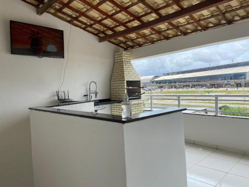 a kitchen with a counter top with a fireplace at Guilherme Hostel in Fortaleza