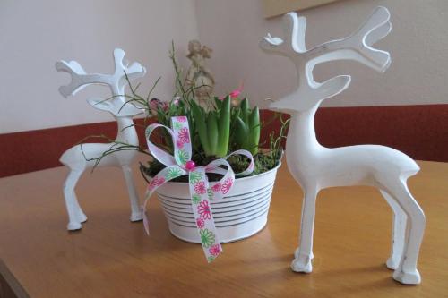 a table with a potted plant and two white deer statues at Apartments Egger Barbara in Gosau