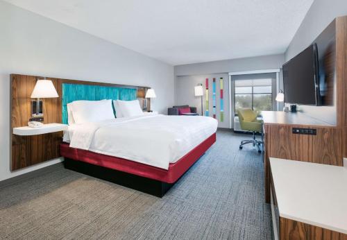 ビロクシにあるHampton Inn Biloxi Beach Boulevardの大きなベッドとデスクが備わるホテルルームです。