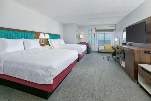 a hotel room with two beds and a flat screen tv at Hampton Inn Biloxi Beach Boulevard in Biloxi