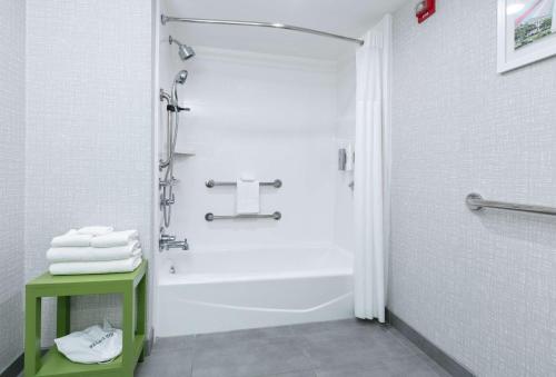 baño blanco con ducha y mesa verde en Hampton Inn Biloxi Beach Boulevard, en Biloxi