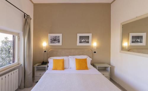 a bedroom with a white bed with two yellow pillows at Hotel Terme Principe in Ischia