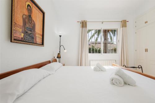 マルベーリャにあるBungalow directly at the beachの白いベッドルーム(大型ベッド1台、白い枕付)