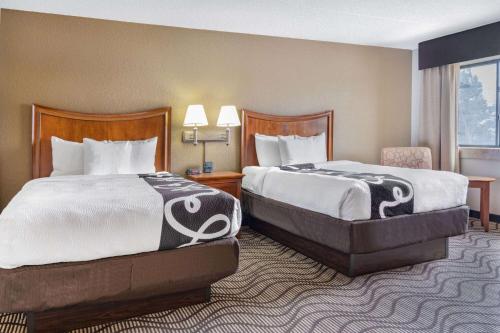 a hotel room with two beds and a table with lamps at La Quinta by Wyndham Minneapolis-Minnetonka in Minnetonka