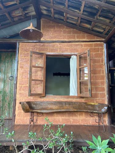 an open window in a brick building with a bench at Abrigo Cipó in Serra do Cipo